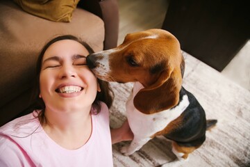 A dog kisses a woman