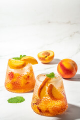 Naklejka na ściany i meble homemade peach sangria with ice cubes, and mint, Refreshing summer homemade cocktails, on a light background, vertical image. top view. place for text