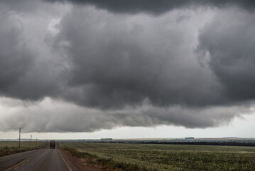 storm clouds over the road and corn field