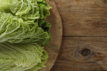 Fresh ripe leaves of Chinese cabbage on wooden table, top view. Space for text