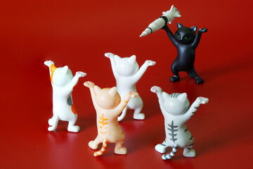 Toy dancing cats from a meme with a rocket on a red background. Apocalyptic anti-war concept. The threat and extortion of the use of nuclear weapons of mass destruction.