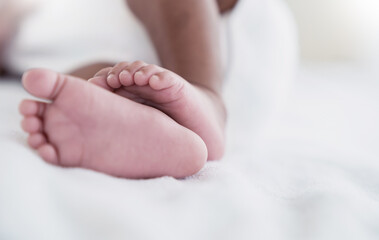 Obraz na płótnie Canvas Closeup feet of newborn African black baby isolated on white hospital bed sheet. Healthcare and medical love lifestyle father or mother’s day background concept banner