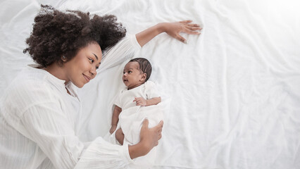 Closeup portrait of beautiful young African American mother day girl kiss healthy newborn baby...