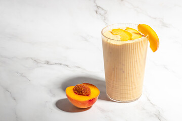Peach drink in a glass with milk on a light background, Healthy eating. Breakfast, snack,...