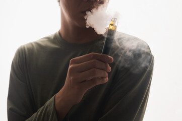 Young man on a white background smoking electronic cigarette, enjoying, a lot of smoke