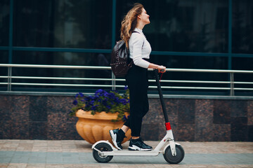 Young woman with electric scooter at the city.