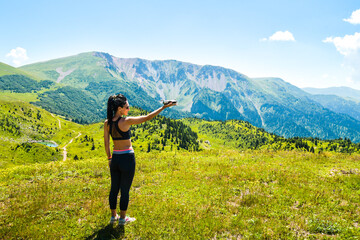 Fototapeta na wymiar Young caucasian woman hold mini white alpine color drone in scenic nature mountains outdoors .Filmmaker shoot drone footage for commercial work outdoors