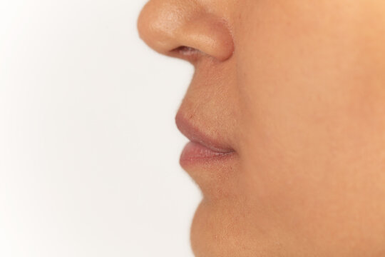 Close-up of female lips on white background before lip augmentation.
