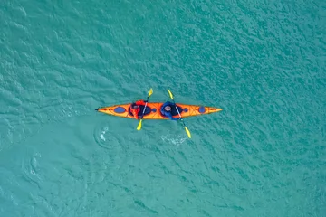 Foto op Canvas Red kayak boat two rowers on blue turquoise water sea, sunny day. Concept teamwork for business plan, aerial top view © Parilov