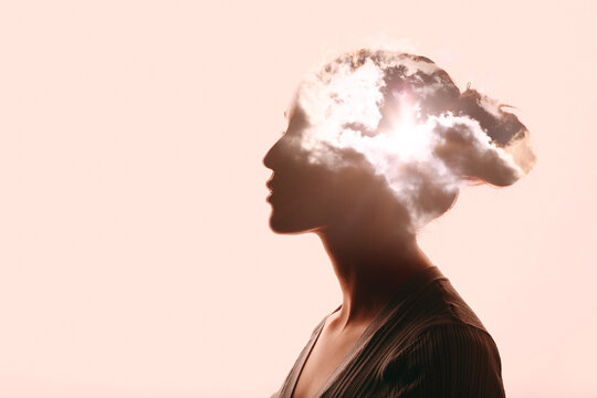 Atmosphere pressure and woman mental health contemplation concept. Multiple exposure clouds and sun on female head silhouette.
