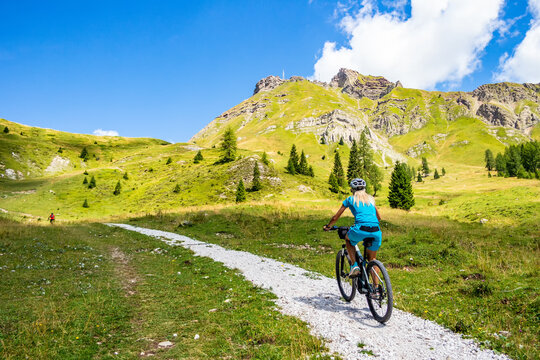 Background with woman cyclist on a path of the Pale di San Martino di Castrozza, Trentino Alto Adige - Italy