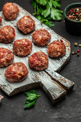 Raw meatballs, minced pork meat on white plate dark background. Culinary, cooking concept. Food recipe background. Close up