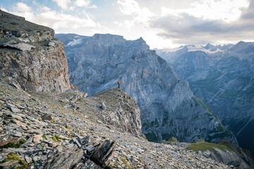 Man on top of mountain. Epic shot of adventure hiking in mountains alone outdoor active. Travel, adventure or expedition concept. Sports, adventure, happiness, freedom