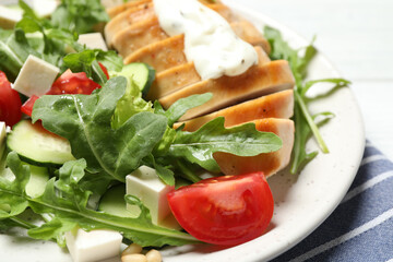 Delicious salad with chicken, arugula and tomatoes on plate, closeup