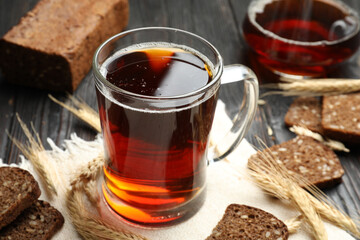 Mug of delicious kvass, spikes and bread on table