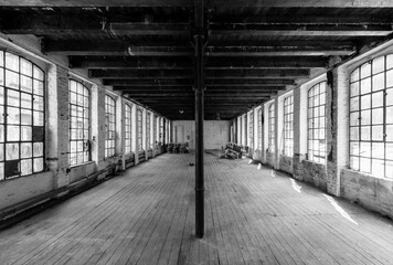 Symmetrical view into a ruined factory in Germany. Lost industrial place with floorboards, two rows...