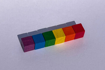 Six wooden cubes in rainbow colors