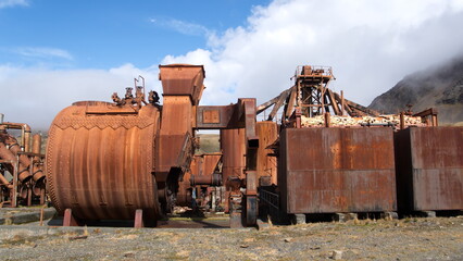 Fototapeta na wymiar Old, rusted whale oil tanks and other industrial eqiupment at the old whaling station in Grytviken, South Georgia Island