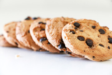 Chocolate chip cookies deliciously lined up on white table, a tasty biscuit snack, selective focus used