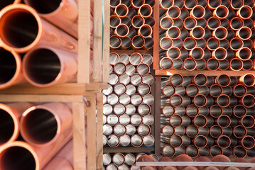 Background of orange plastic sewage pipes used at the building site. Texture and pattern of plastic drainage pipe. Light through tubes.