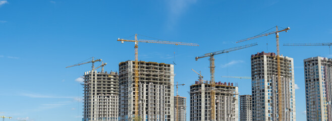 Construction of a multi-story residential buildings. A lot of construction equipment, cranes work....
