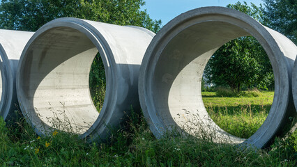 Reinforced concrete storm sewer pipes of large diameter stacked at a construction site. Sewer Large...