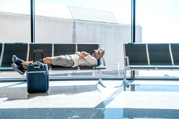 man in the airport sleeps on the armchairs - 524293403