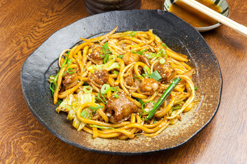 もちもちのうどんとぷりぷりの牛ホルモンを、コクのあるタレで香ばしく炒めた「ホルモンうどん」。キャベツやネギの食感とホルモンの旨味が絶妙に絡み合う、スタミナ満点のご当地グルメです。居酒屋や鉄板焼きメニューの紹介に最適な、食欲をそそる高品質な料理素材です。 | Stir-fried Udon noodles with beef offal "Horumon Udon".