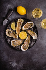 Opened fresh oysters on a plate, served with lemon and ice.