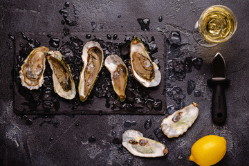 Opened fresh oysters on a plate, served with lemon and ice.