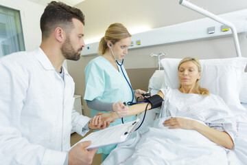 Obraz premium doctor taking the blood pressure of her patient