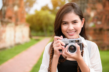 young beautiful woman traveling and taking photo at thai historical Park, Holidays and cultural tourism concept.