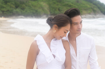 Happy young couple wearing white dress on the beach on holidays, travel, romantic, wedding concept