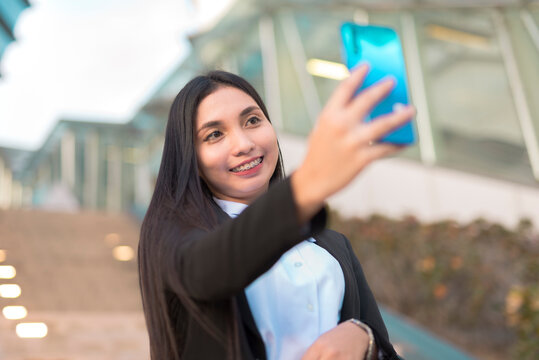 A Working-age Lady In Her 20s Takes A Picture Of Herself Before Heading To Work. An Asian Woman In Corporate Attire Is Capturing A Selfie To Document Her Day After Being Granted An Early Leave.