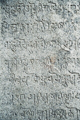 Obraz premium Inscriptions of ancient language carved on the stone walls at Hindu temple in Mahabalipuram, Tamilnadu, India. Ancient tamil inscriptions carved in the exterior temple walls in Mahabalipuram.