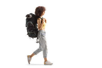 Full length profile of a young female backpacker walking