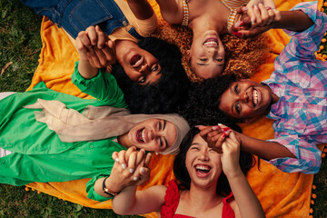 Obraz premium Girls lying in circle holding hands