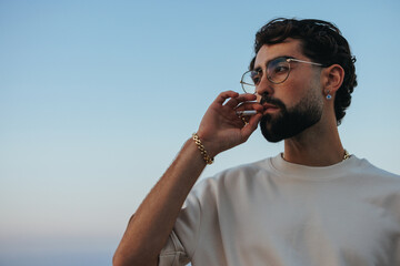 Urban man smoking cigarette at beach