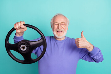 Photo of handsome aged man arm hold wheel demonstrate thumb up feedback isolated on turquoise color background