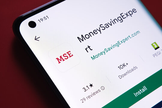 moneysavingexpert app seen in Google Play Store on the smartphone screen placed on red background. Close up photo with selective focus. Stafford, United Kingdom, August 2, 2022.