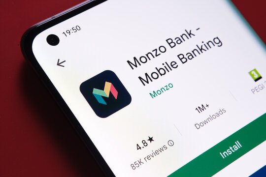 monzo app seen in Google Play Store on the smartphone screen placed on red background. Close up photo with selective focus. Stafford, United Kingdom, August 2, 2022.