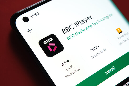 BBC iPlayer app seen in Google Play Store on the smartphone screen placed on red background. Close up photo with selective focus. Stafford, United Kingdom, August 2, 2022.