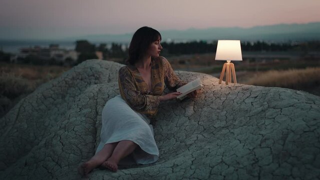 Girl read book at night on the mountain with abat jour lamp