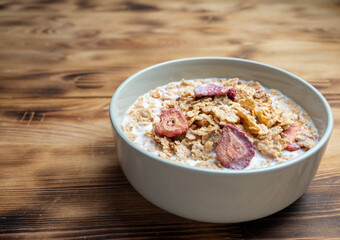 A cup with muesli and fresh berries on a wooden table. Healthy food, snack or breakfast.