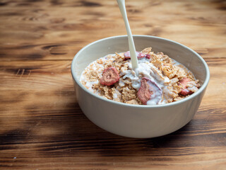 A cup with muesli and fresh berries on a wooden table. Healthy food, snack or breakfast.