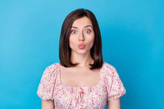 Photo of adorable young woman bob hairstyle send blowing kiss wear flower painted blouse isolated on blue color background