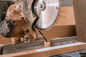 Sawing machine for wood in the workshop for the production of furniture. Woodworking circular saw and wooden bar for cutting.