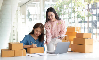 Portrait of Starting small businesses SME owners, two Asian woman check online orders Selling products working with boxs freelance work at home office, sme business online small medium enterprise