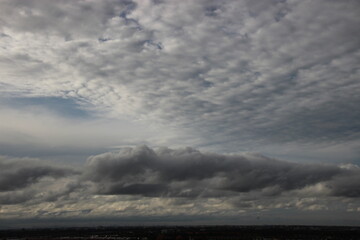 Fototapeta na wymiar dark gray rainy clouds sky with city background
