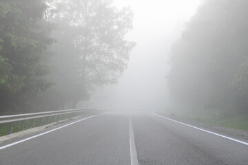 Empty misty road in forest